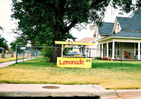 Invest in community | A photograph of a house with a lemonade stand