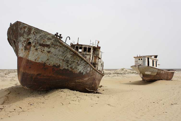 The world’s lakes and freshwater are in peril | An image of a boat in a dried up lake