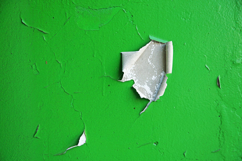 ESG communications need a makeover | An image of a green wall with chips in the paint