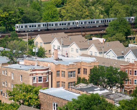 Chicago Transit Authority Green Line elevated train and tracks passes by neighborhood homes and housing
