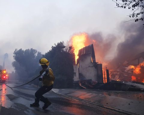 A firefighter battles the advancing Palisades Fire as it burns a structure in the Pacific Palisades neighborhood of Los Angeles, Tuesday, Jan. 7, 2025.