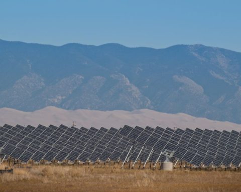 A series of large solar panels forms a symmetrical line at a power plant in Colorado.